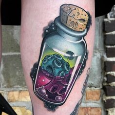 a woman's leg with an elephant in a glass jar tattoo on her thigh