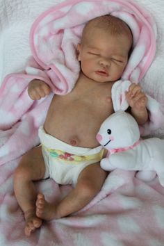 a baby is laying down with a stuffed animal