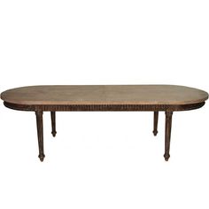 an oval dining table with four legs and a marble top, in the style of louis ii