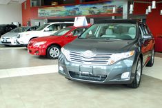 several cars are parked in a showroom