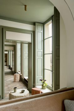 an empty room with green walls and large windows