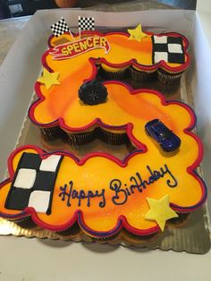 a birthday cake in the shape of a race car on top of a sheet cake