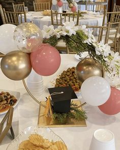 the table is set with balloons, snacks and desserts