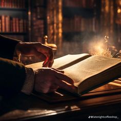 a person is holding an open book in front of a desk with bookshelves