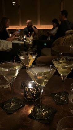 three martini glasses sitting on top of a table