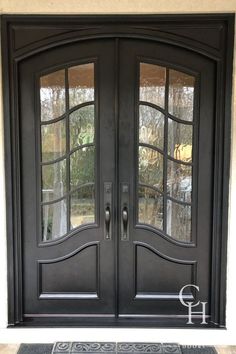 a black double door with two sidelights and glass panels on the front entrance to a home