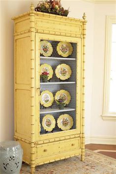 a yellow china cabinet sitting in the corner of a room