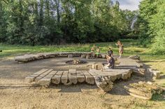 children playing around a fire pit made out of logs