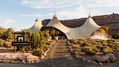 an image of a tent set up in the desert with trees and rocks around it