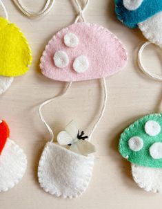 four felt ornaments are hanging from strings on a table