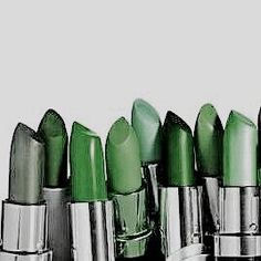 several green lipsticks lined up in a row on top of each other with silver caps