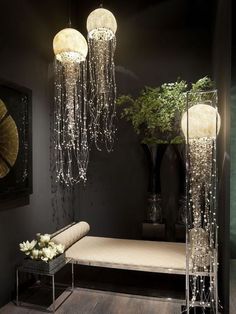 a room that has some lights hanging from the ceiling and two vases with flowers in them