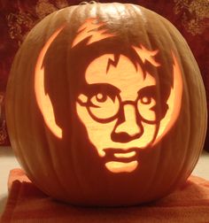 a carved pumpkin with the likeness of stephen fry on it