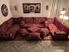 a red couch sitting on top of a wooden floor