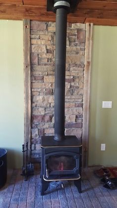 a wood burning stove sitting inside of a living room next to a brick fire place