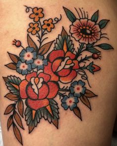 a woman's thigh with flowers and leaves on it