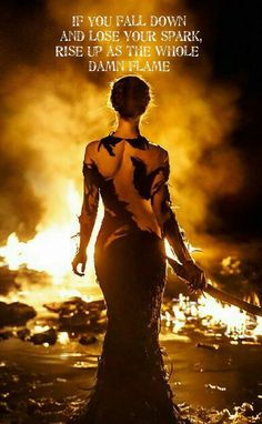 a woman standing in the water at night with her back turned to the camera, wearing a black and yellow dress