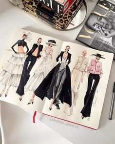 an open book with fashion illustrations on it next to a pen and scissors, some books