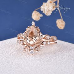 an engagement ring set with a pear shaped morganite surrounded by smaller round diamond accents