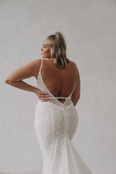 a woman in a white wedding dress with her back to the camera