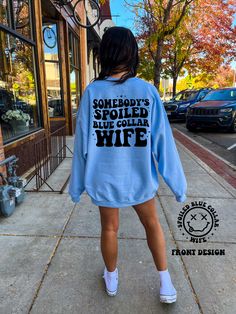 This Somebody spoiled blue collar wife tee or sweatshirt comes in either light blue or royal blue, perfect for the hardworking woman in your life! Show her you care and let her know she's someone special. Blue Trendy Sweatshirt With Letter Print, Trendy Blue Sweatshirt With Letter Print, Trendy Blue Letter Print Sweatshirt, Somebody’s Spoiled Blue Collar Wife, Blue Casual Sweatshirt With Text Print, Western Tee, Bling Bags, Church Outfits, Front Design