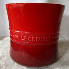 a red bowl sitting on top of a white table cloth