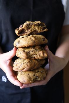 a person holding a stack of cookies in their hands