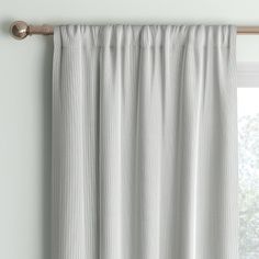 a white curtain hanging on the side of a window