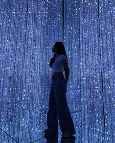 a woman standing in front of a blue curtain with stars on it's walls