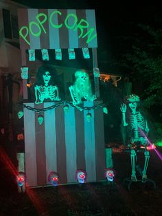 halloween decorations in front of a house with neon lights and skeletons on the outside wall