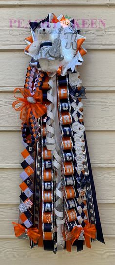 an orange and black ribbon is attached to the side of a building with scissors in it