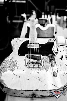 an old guitar sitting on top of a table next to other instruments and equipment in black and white