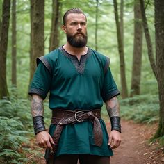 a man with a beard wearing a green outfit in the woods