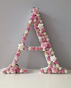 the letters are made out of flowers and decorated with white, pink, and red roses