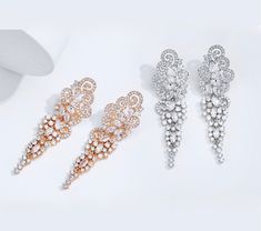 A beautiful pair of bridal earrings that is sure to make a bold statement on your Wedding Day! Adorned with glowing cubic zirconia that capture the light from every angle with a perfectly translucent appeal, the earrings are rhodium/rose gold plated for a bright finish which enhances the intricate detailing and conveys a modern take on old elegance. Length of the earring is 2.4" (approx. 6.1cm); Width: 0.7" (approx. 1.8cm); Weight: 12g. Available in Silver and Rose Gold finishes. To make your ch Cubic Zirconia Bridal Earrings, Bridal Earrings, On Your Wedding Day, Exquisite Design, Rose Gold Plates, Gold Finish, Crystal Rhinestone, Wedding Jewelry, Silver Gold