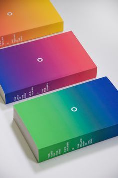 three different colored books sitting on top of each other