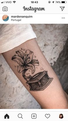 a black and white photo of a tattoo on the arm with a flower in it