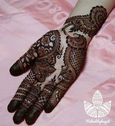 henna tattoo on the palm of a woman's hand, with intricate designs