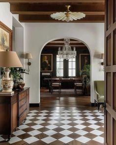 an entry way with checkered flooring and chandelier