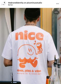 the back of a man wearing an orange and white t - shirt that says nice