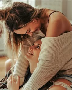 two women are smiling and hugging each other