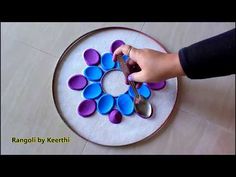 someone is decorating a plate with purple and blue decorations