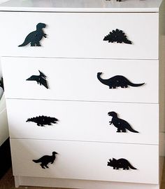 a white dresser with black dinosaurs on it