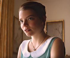 a woman in a blue and white dress looking at the camera with an intense look on her face