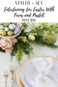 an easter table setting with flowers, eggs and greenery on the table in front of it