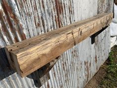 a piece of wood sitting on top of a metal wall