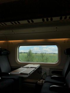 the view from inside an airplane looking out at a field and trees in the distance