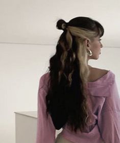 a woman with very long hair standing in front of a mirror wearing a blue shirt