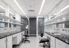 a lab with white cabinets and black counter tops is shown in this image, there are two stools on each side of the room