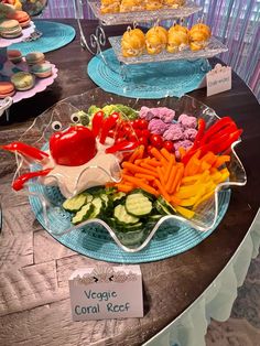 a table topped with trays filled with different types of veggies and muffins